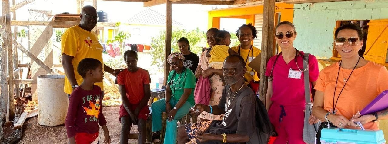Hope for Humanity mission team providing care to community family under porch shelter