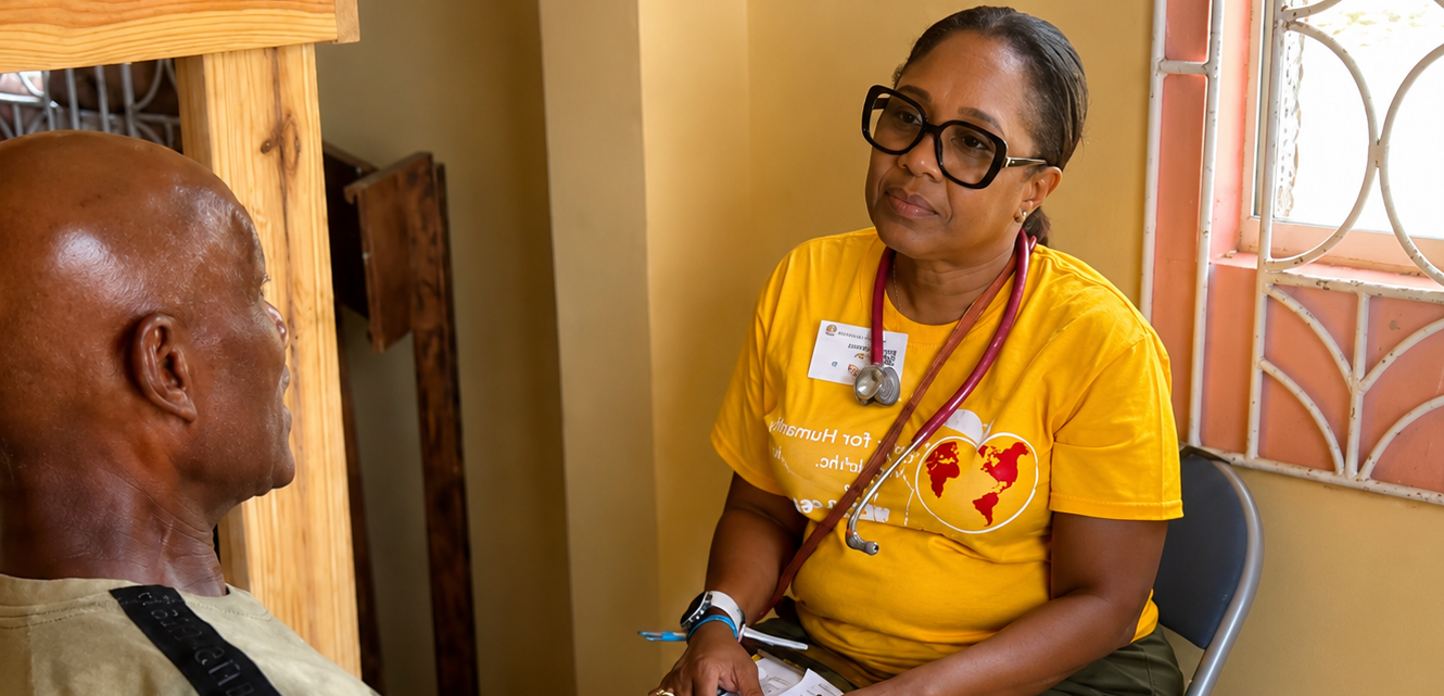 Hope for Humanity doctor in yellow HHW shirt consulting with elderly patient