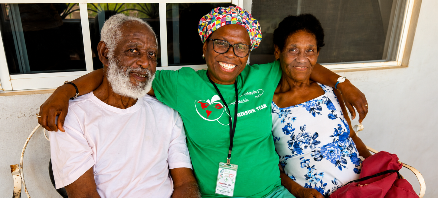 Hope for Humanity volunteer in green mission team shirt smiling with elderly couple