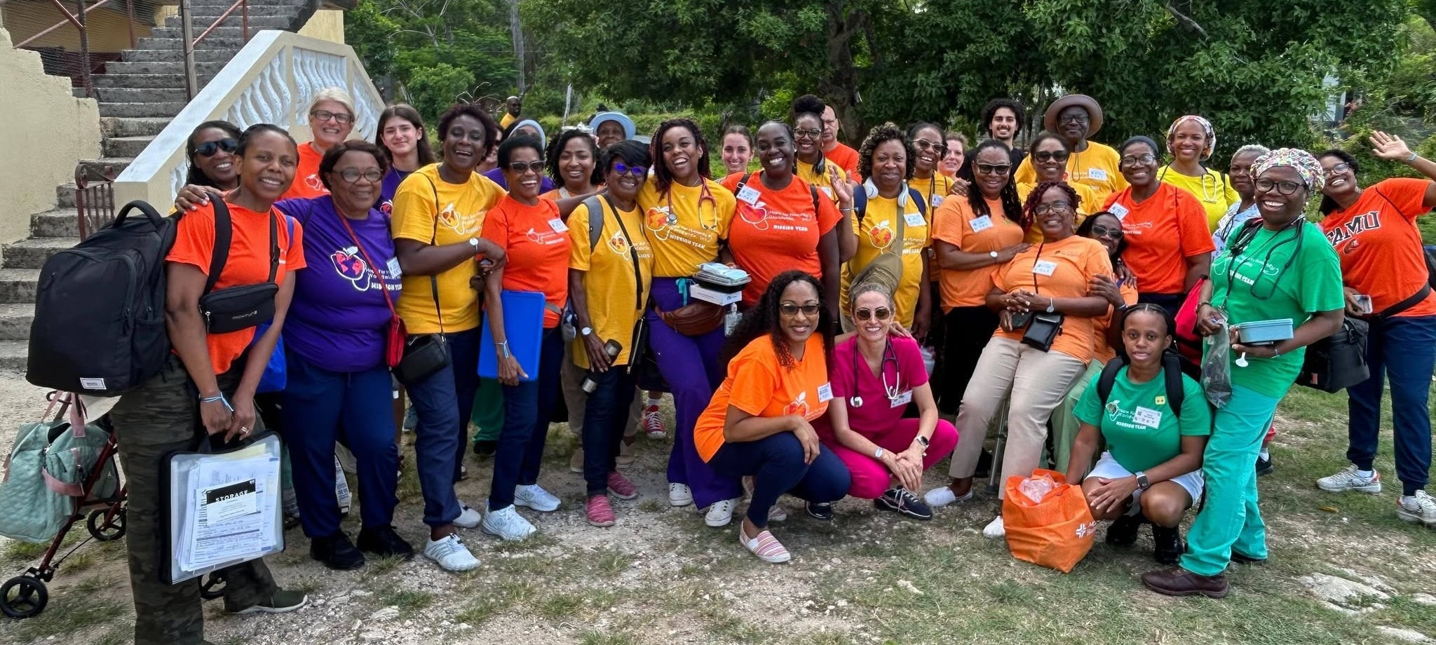 Hope for Humanity large mission team in orange and yellow shirts outdoors