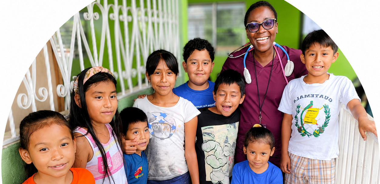 Hope for Humanity nurse smiling with group of Guatemalan children outdoors