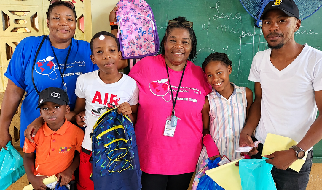 Hope for Humanity volunteers distributing backpacks and school supplies to children in a classroom