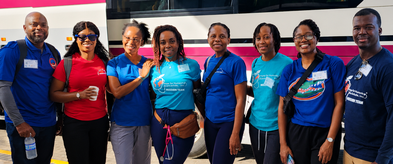 Hope for Humanity mission team smiling together in front of bus