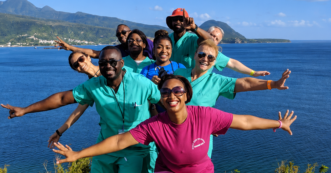 Hope for Humanity mission team celebrating by the sea in scrubs