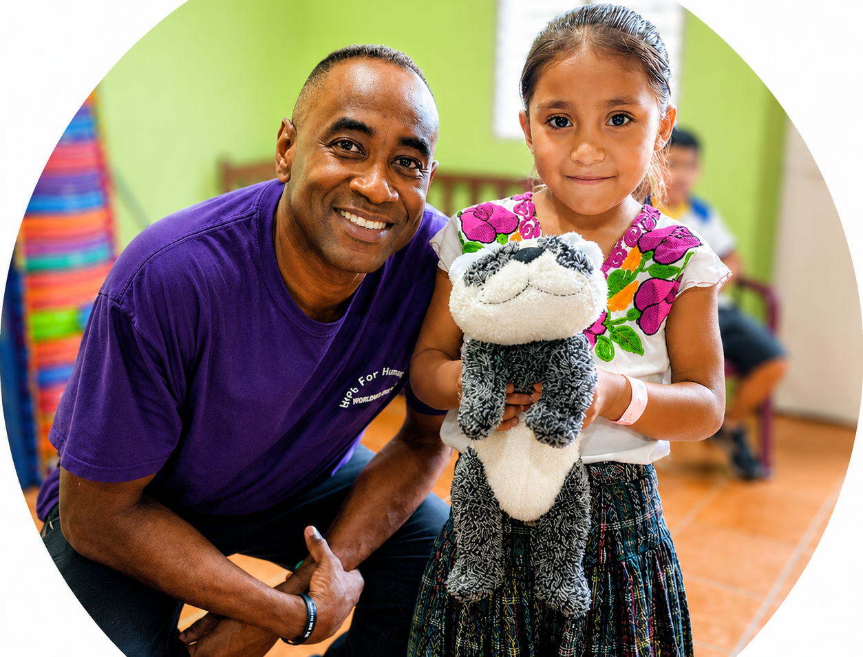 Hope for Humanity volunteer with girl holding stuffed animal at mission