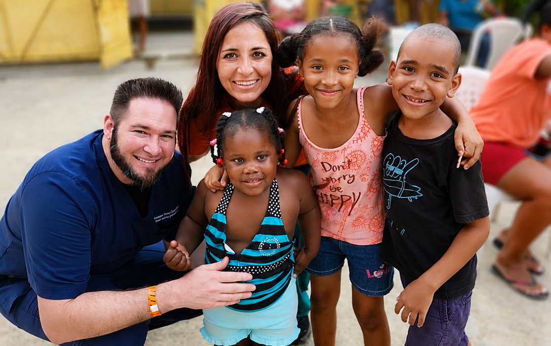 Hope for Humanity volunteers smiling with children at community mission