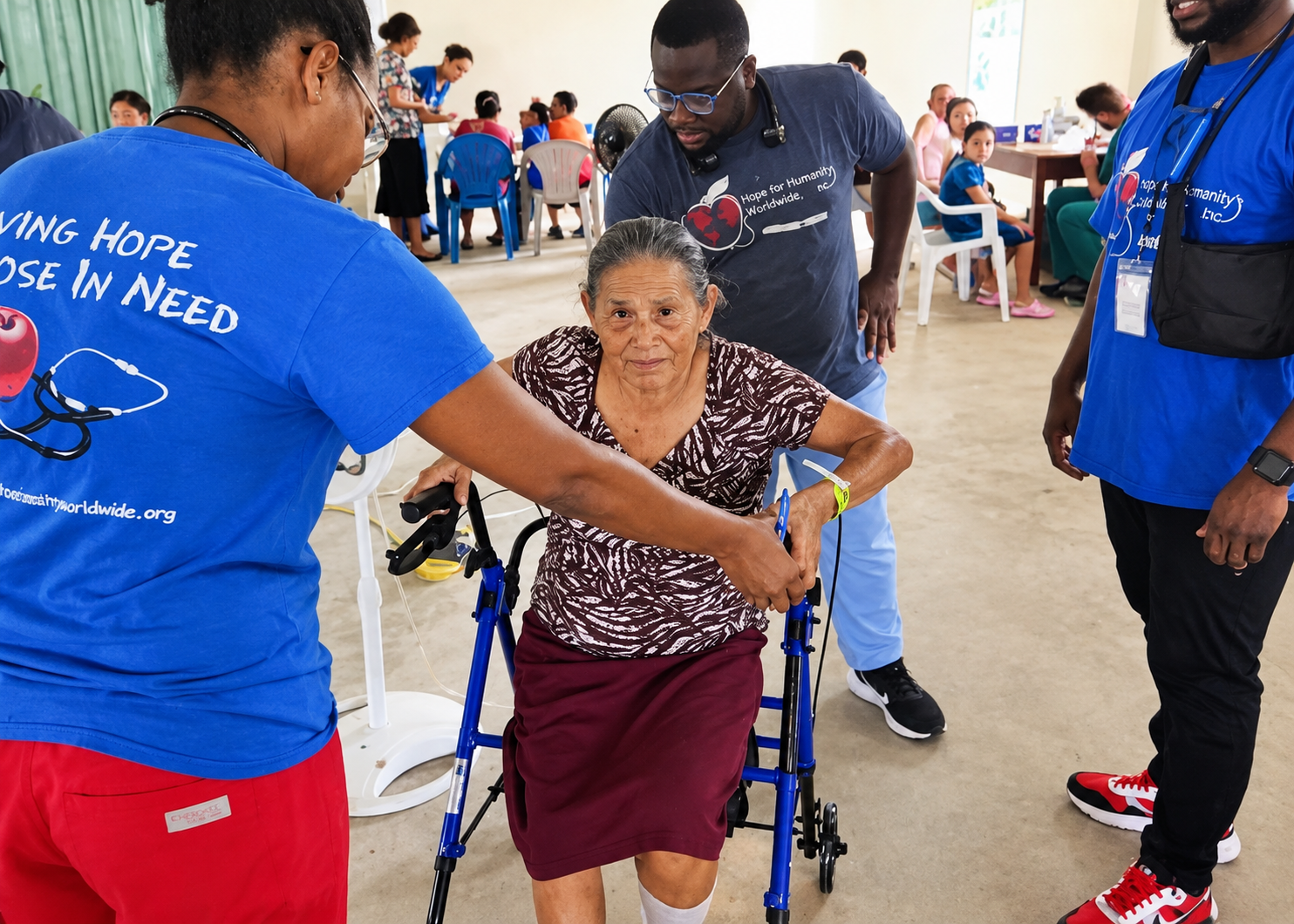 Hope for Humanity volunteers helping elderly woman with her walker at indoor clinic